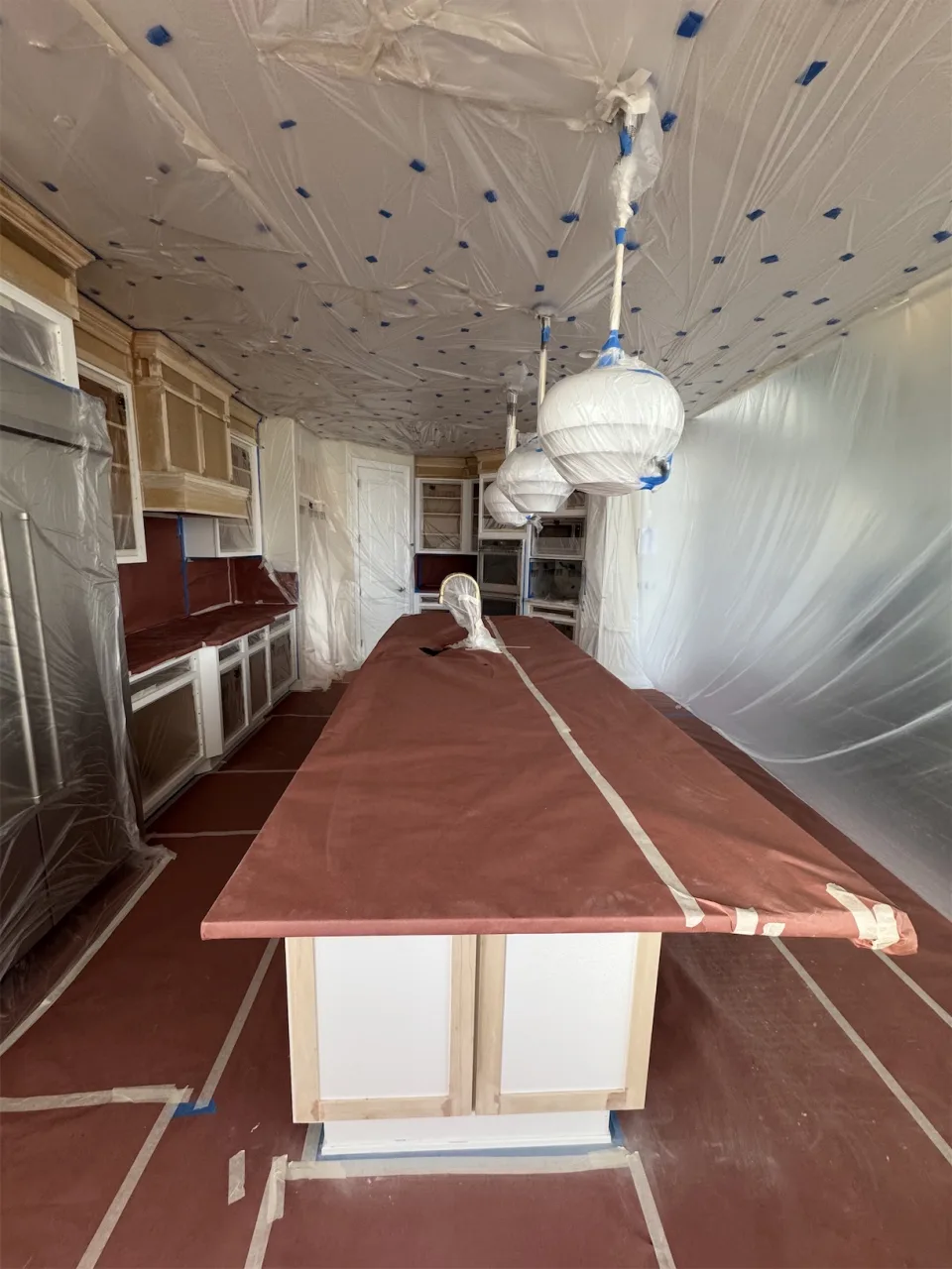 Techo y paredes forrados con plástico protector durante la remoción y preparación en una cocina