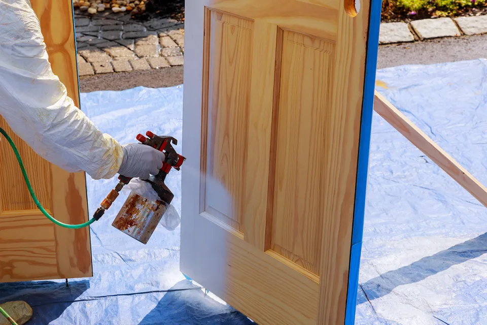 Detalle de gabinetería blanca con molduras y refrigerador de acero inoxidable empotrado en una cocina